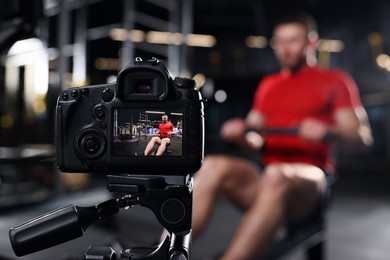 Man recording workout at gym, focus on camera. Online fitness trainer