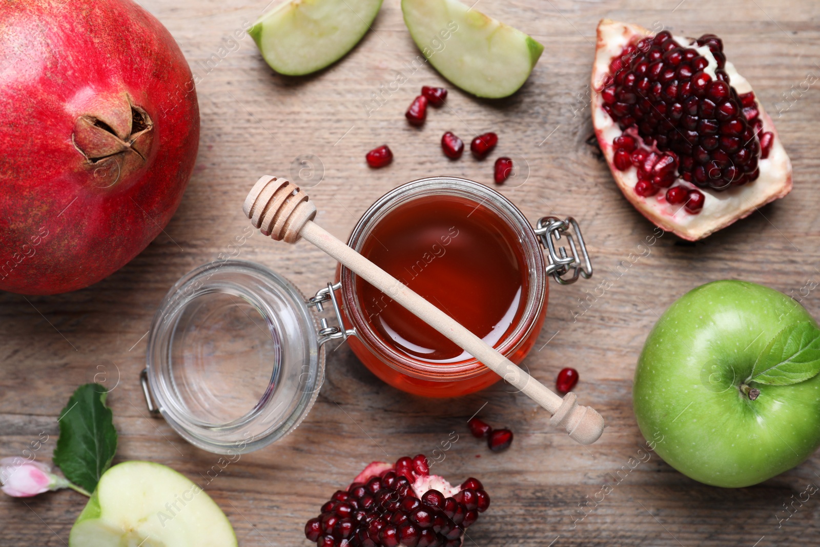 Photo of Honey, pomegranate and apples on wooden table, flat lay. Rosh Hashana holiday