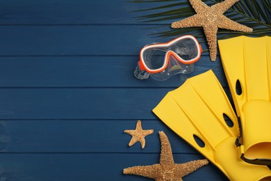 Photo of Flat lay composition with beach objects on blue wooden background, space for text