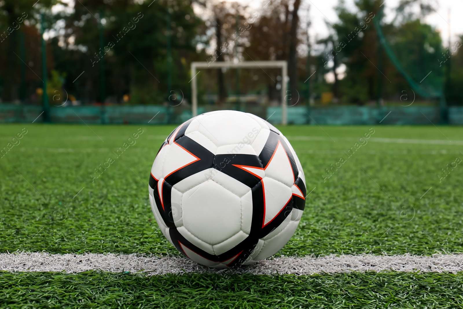 Photo of New soccer ball on green football field