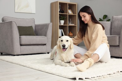 Photo of Happy woman with cute Labrador Retriever dog on floor at home. Adorable pet