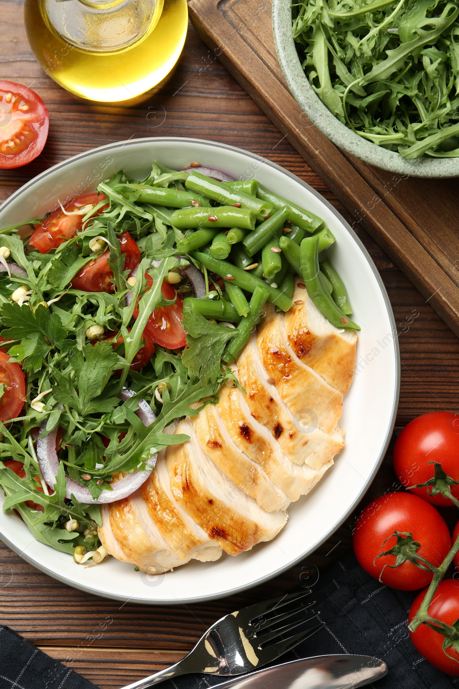 Photo of Healthy meal. Tasty salad and chicken breast in bowl on wooden table, flat lay