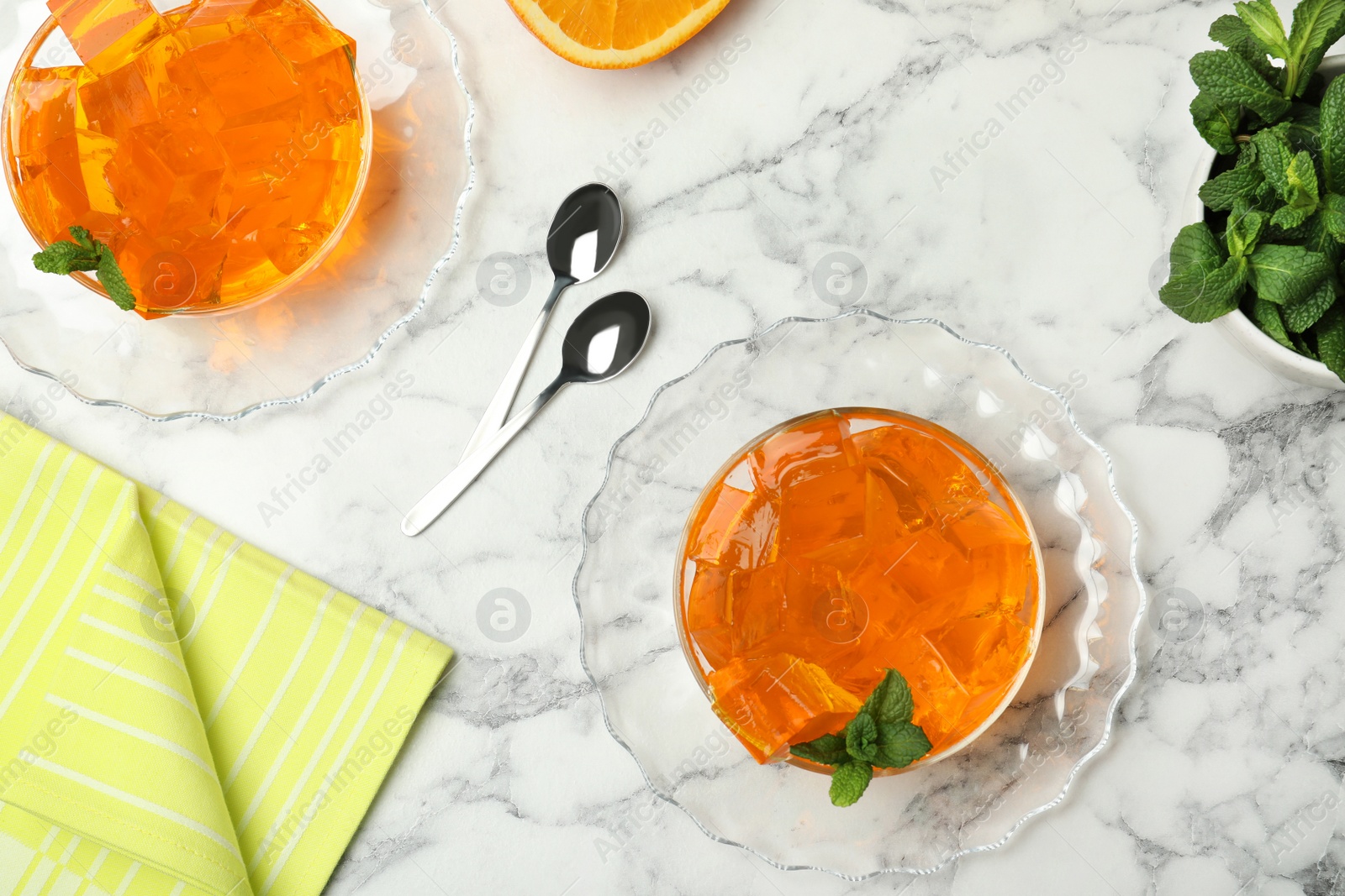 Photo of Flat lay composition with orange jelly in  bowls on marble table