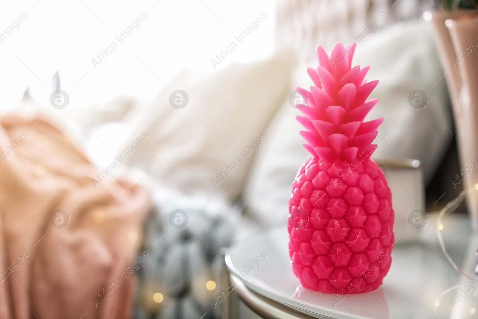 Photo of Pineapple shaped candle on bedside table in room