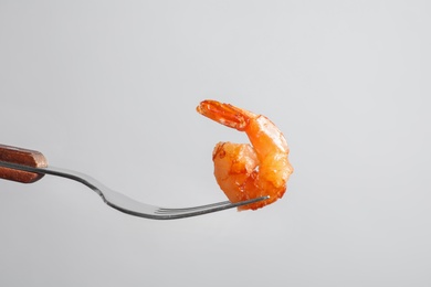 Photo of Fork with delicious fried shrimp on light background