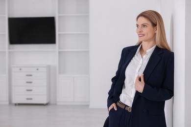 Happy real estate agent in new apartment. Space for text