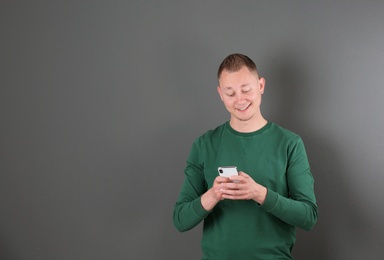 Photo of Portrait of handsome man with mobile phone on color background