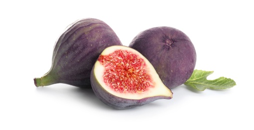 Photo of Whole and cut purple figs on white background