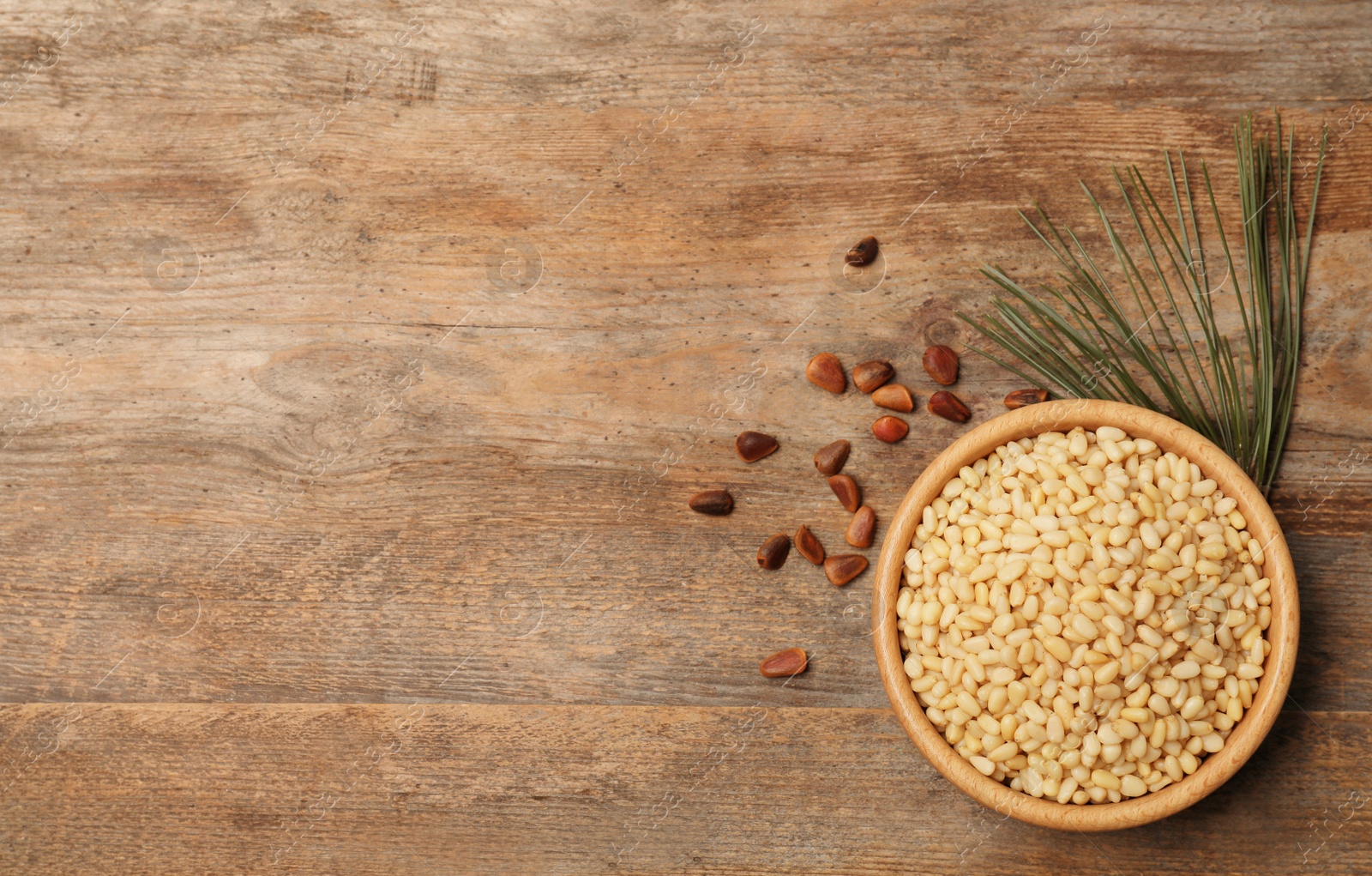 Photo of Flat lay composition with pine nuts and space for text on wooden background