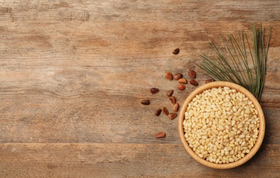 Flat lay composition with pine nuts and space for text on wooden background