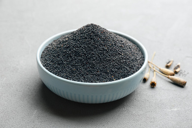 Poppy seeds in bowl on grey table