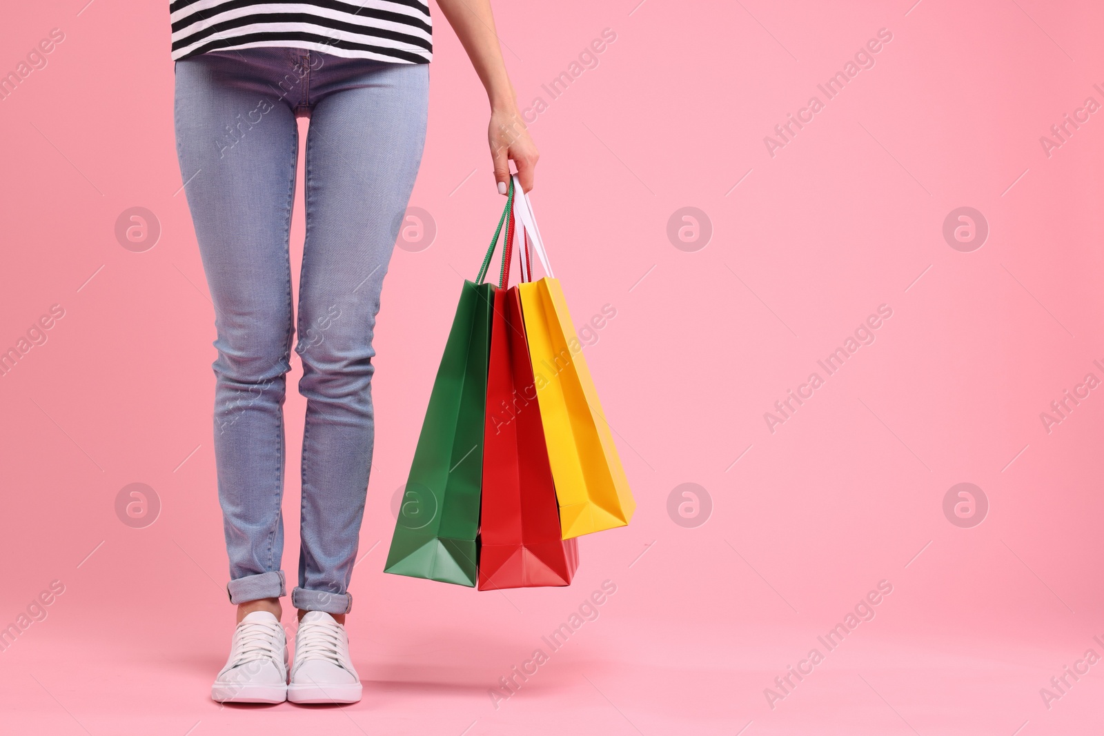 Photo of Woman with shopping bags on pink background, closeup. Space for text