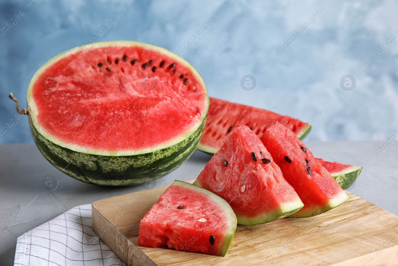 Photo of Wooden board with juicy watermelon slices on table