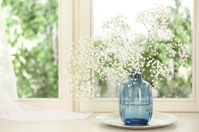 Beautiful fresh flowers on window sill indoors. Space for text