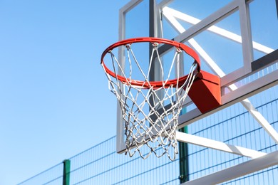 Basketball hoop with net outdoors on sunny day