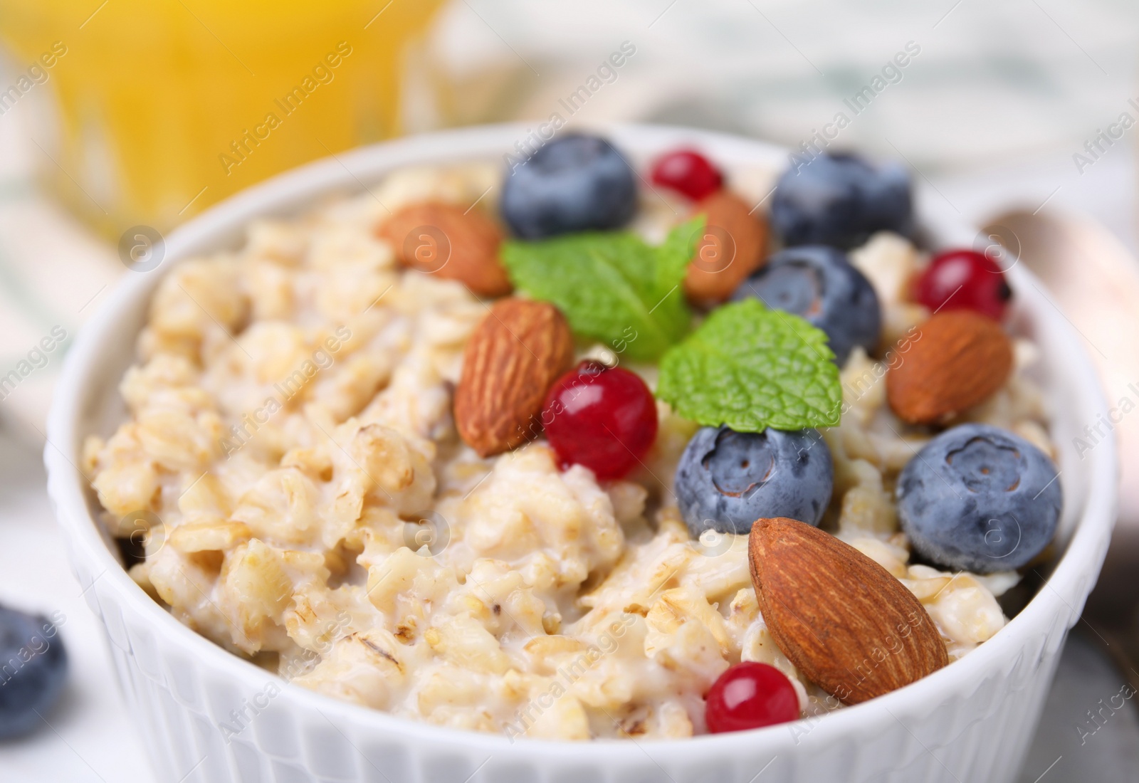 Photo of Bowl of oatmeal with berries. almonds and mint, closeup