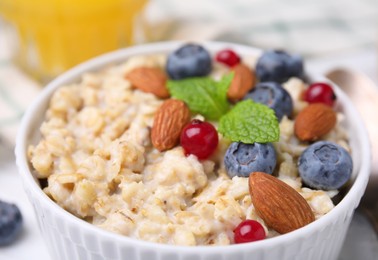 Bowl of oatmeal with berries. almonds and mint, closeup