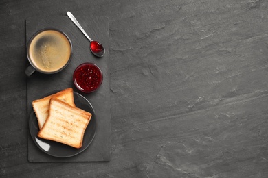 Photo of Tasty breakfast with coffee, toasts and jam on dark table, flat lay. Space for text