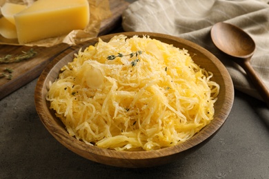 Photo of Bowl with cooked spaghetti squash on gray table