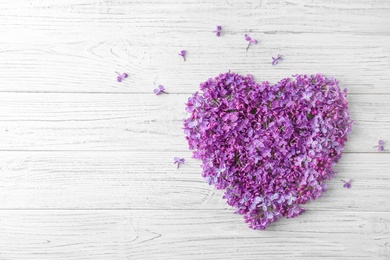 Photo of Heart made of blossoming lilac on wooden background, top view. Spring flowers