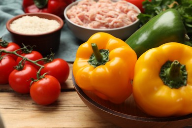 Photo of Making stuffed peppers. Vegetables and ground meat on wooden table, closeup
