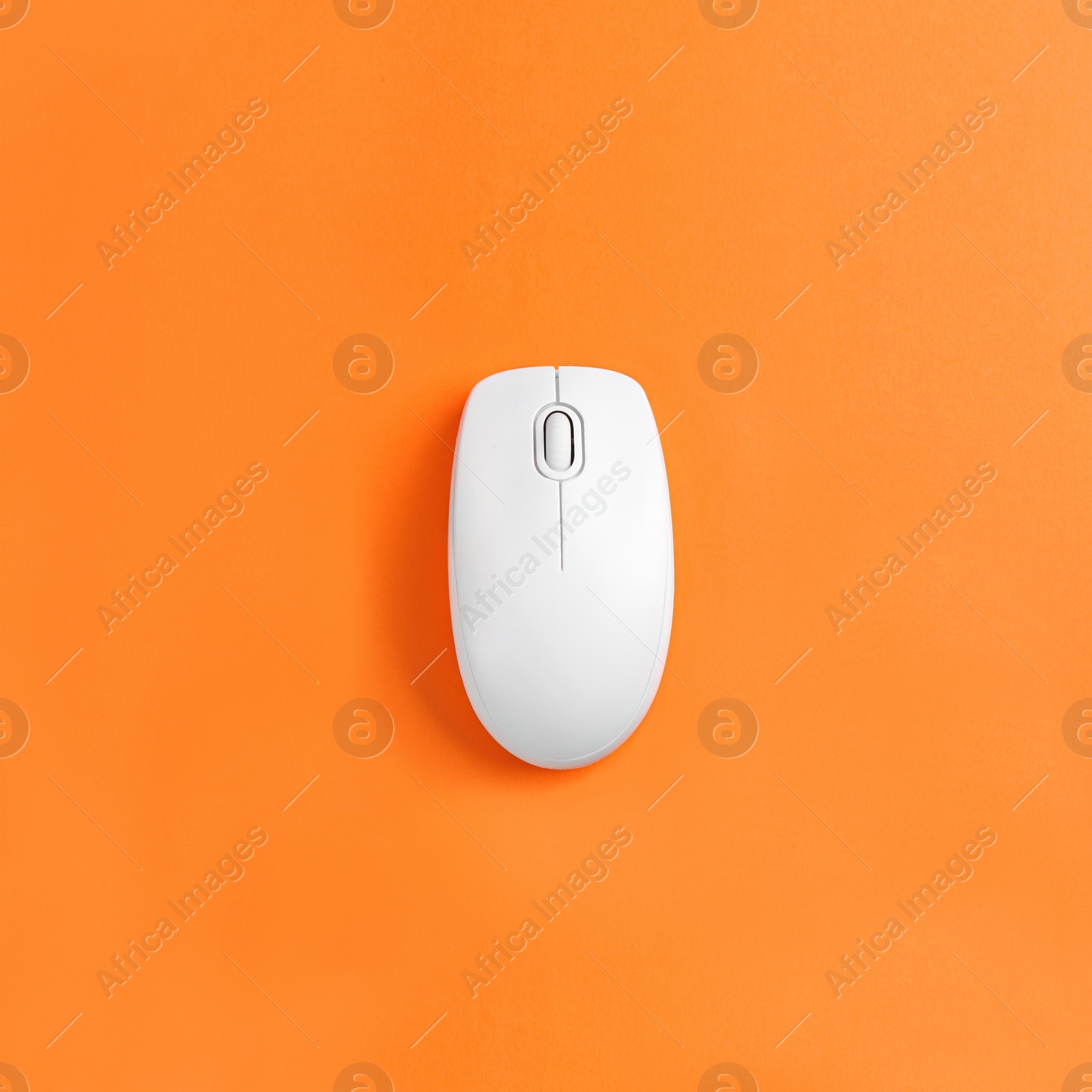 Image of Modern wireless computer mouse on orange background, top view