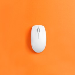 Modern wireless computer mouse on orange background, top view