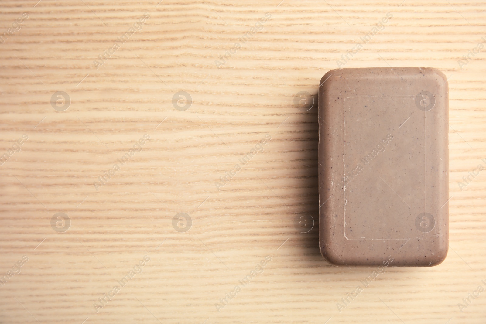 Photo of Soap bar and space for text on wooden background, top view