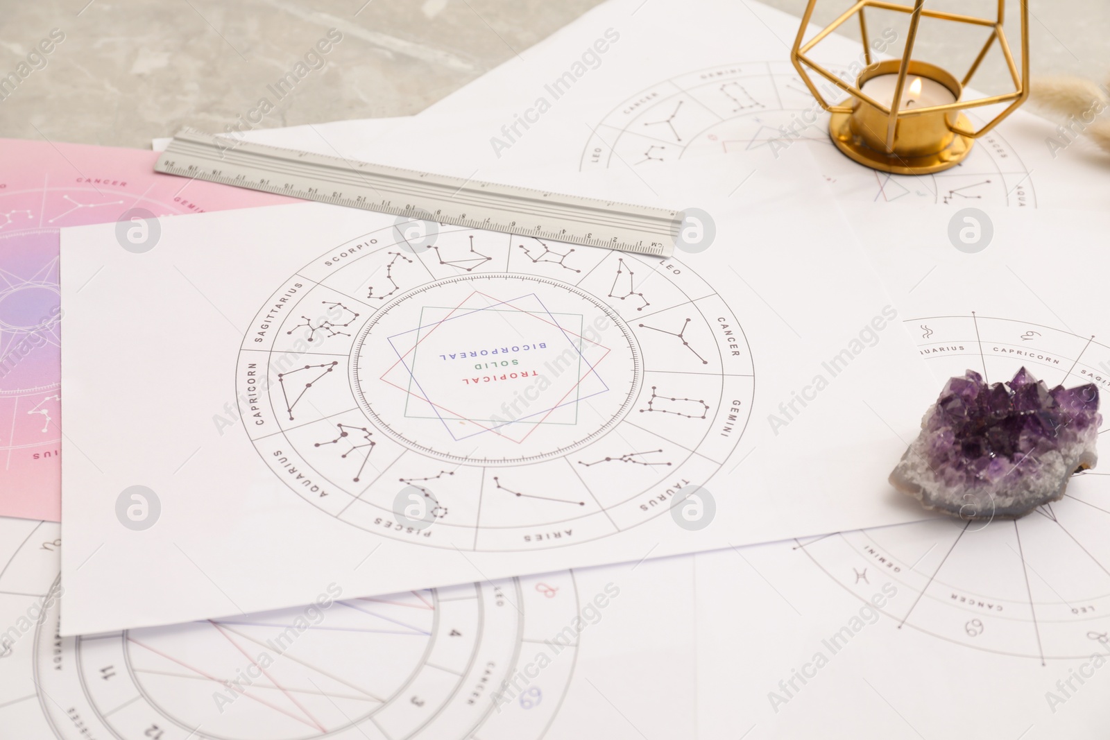 Photo of Zodiac wheels and natal charts for astrological predictions on table, closeup