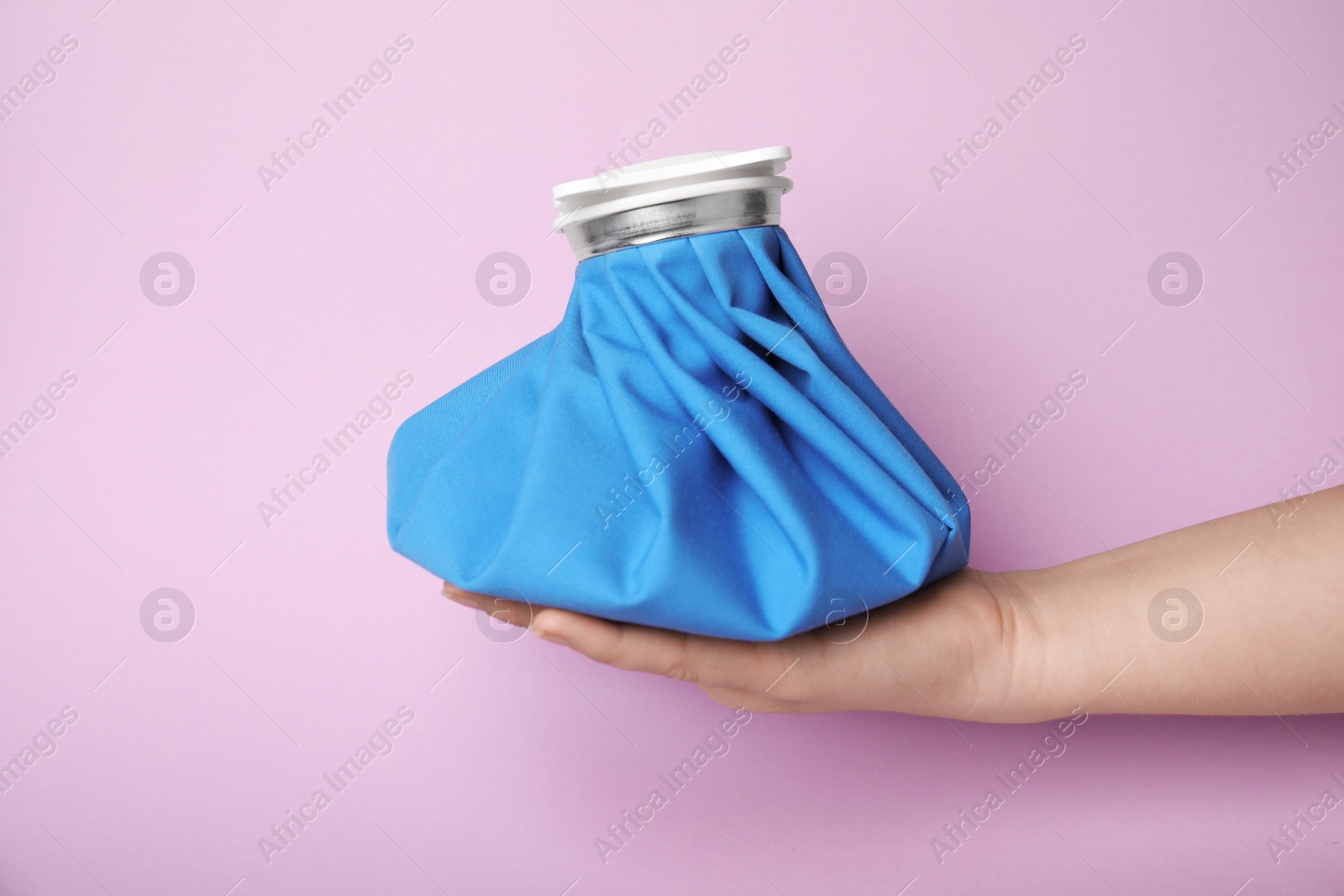 Photo of Woman holding ice pack against lilac background, closeup