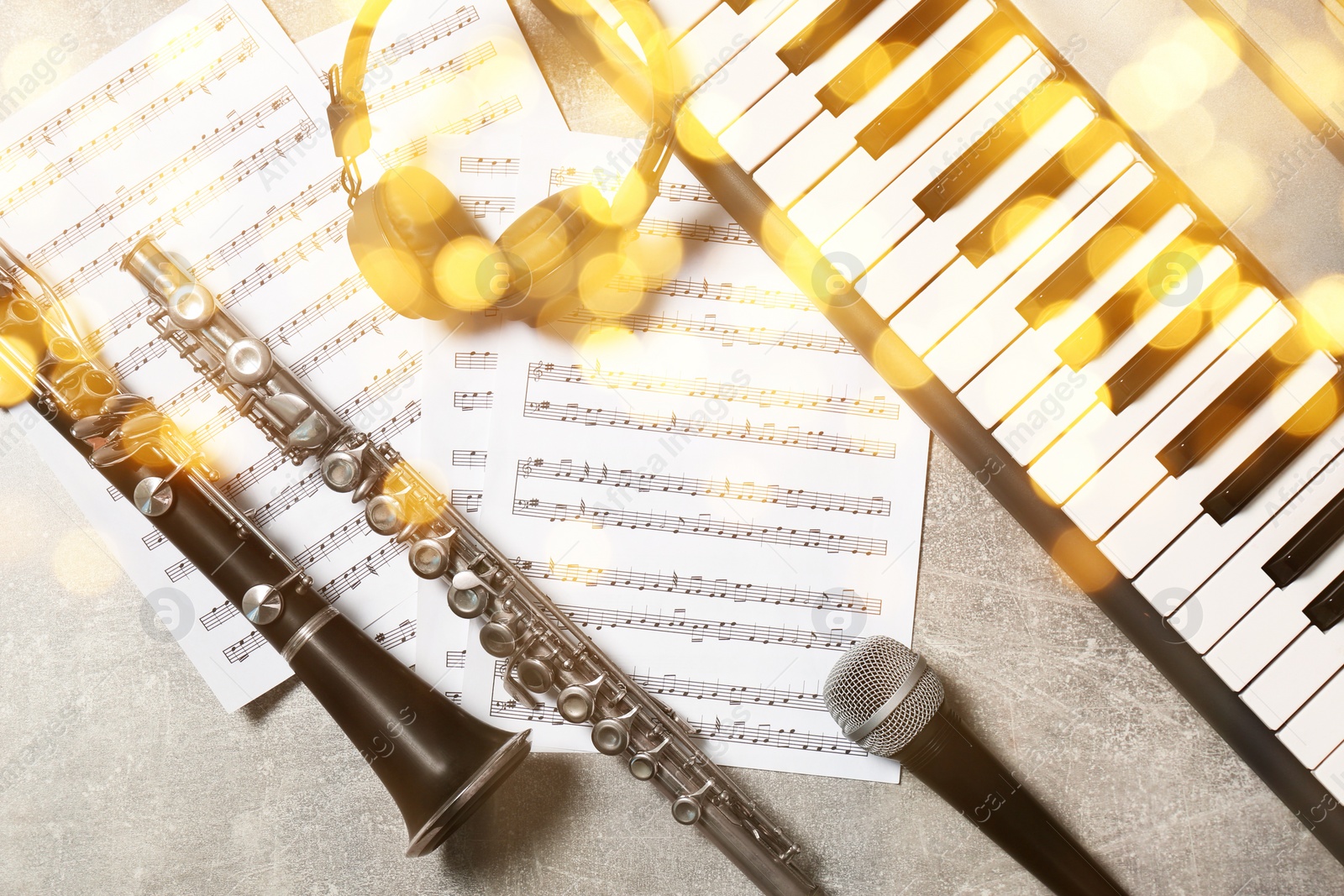 Image of Christmas and New Year music. Headphones and different musical instruments on grey background, bokeh effect