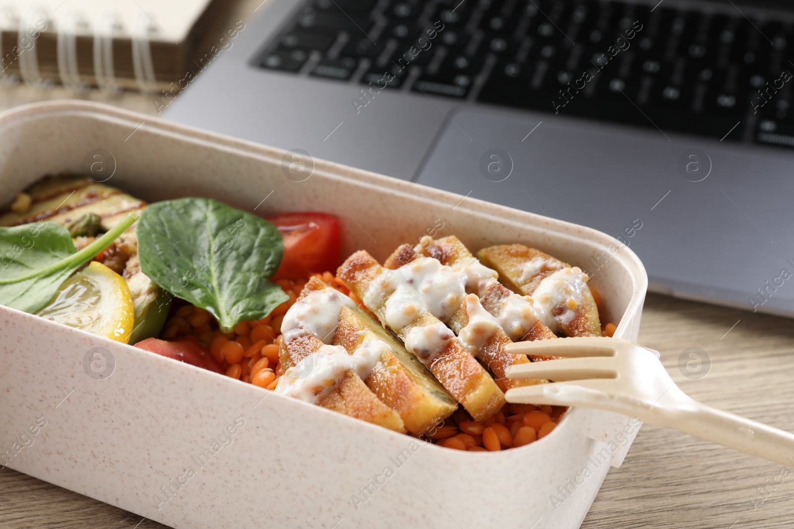 Photo of Healthy products high in vegetable fats near laptop on wooden table, closeup