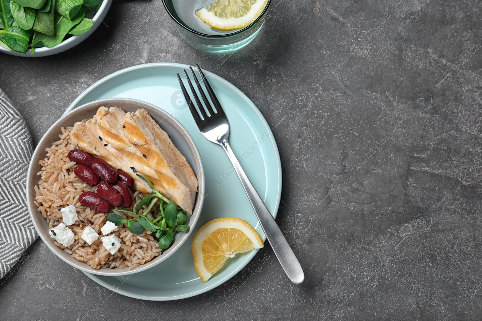 Photo of Tasty rice with beans served on grey table, flat lay. Space for text