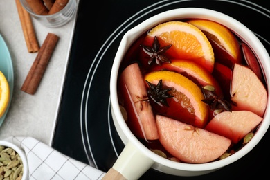 Photo of Delicious hot mulled wine on stove, flat lay