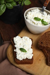 Bread with cottage cheese and basil on table