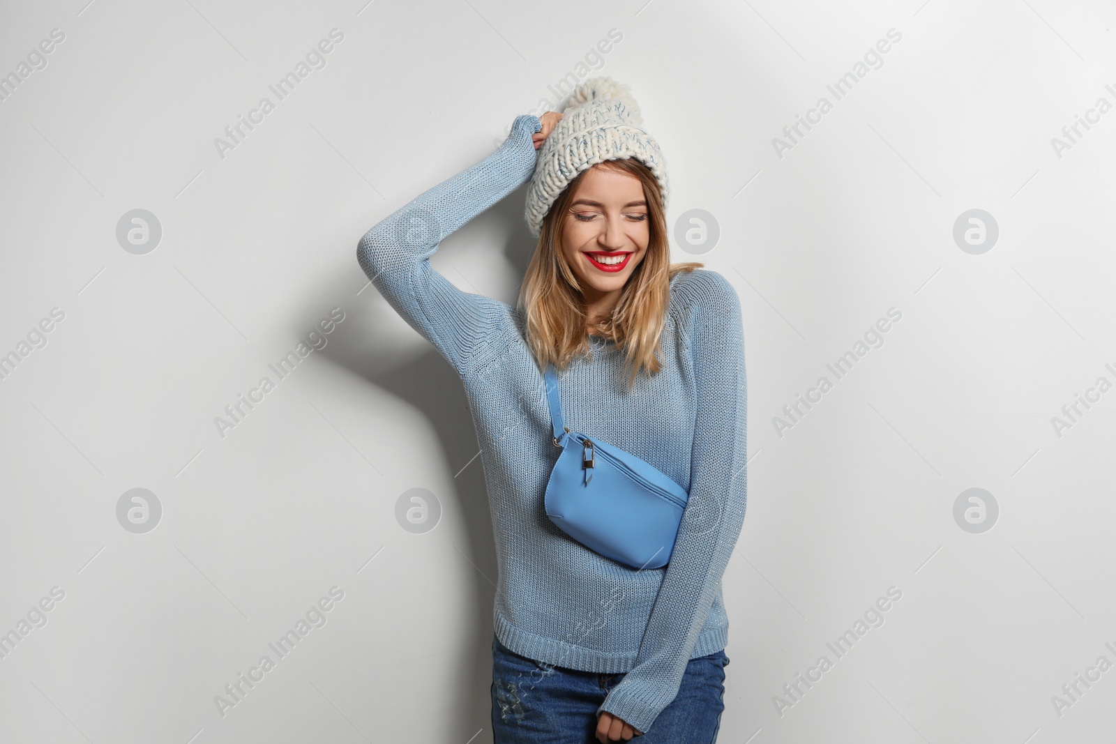 Photo of Beautiful young woman in warm sweater with bag on white background