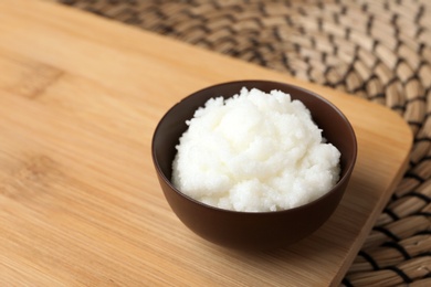 Shea butter in bowl on wooden board. Space for text