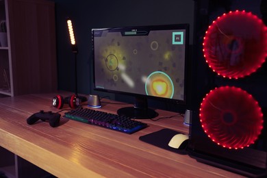 Photo of Modern computer and RGB keyboard on wooden table in room