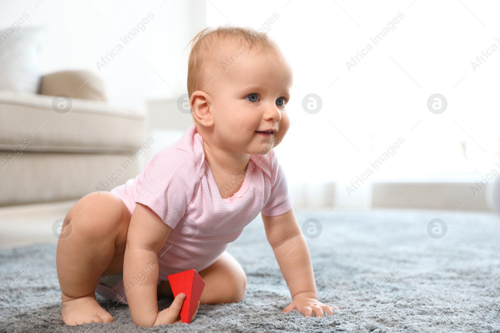 Photo of Cute baby girl playing on floor in room. Space for text