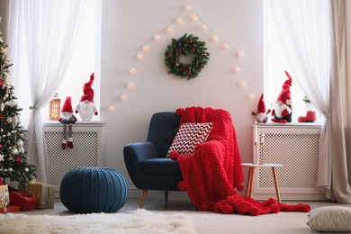 Photo of Cute Christmas gnomes in room with other festive decorations
