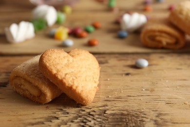 Photo of Delicious cookies on wooden table, closeup. Space for text