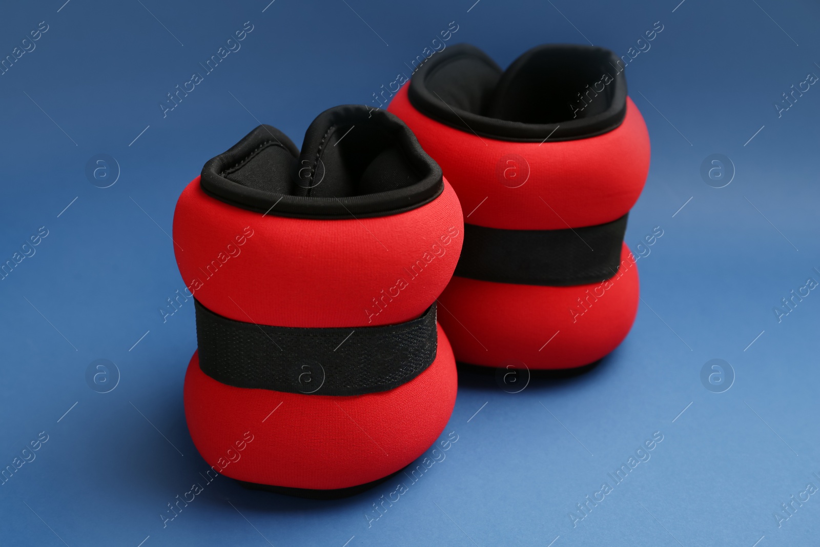 Photo of Stylish red weighting agents on blue background