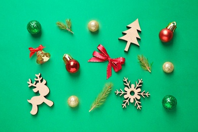 Flat lay composition with Christmas tree branches and festive decor on green background