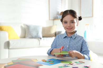 Photo of Little girl making greeting card at table indoors, space for text. Creative hobby