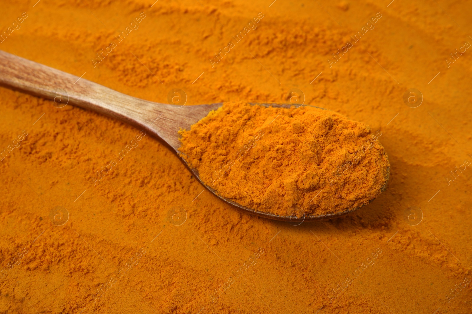 Photo of Aromatic saffron powder and wooden spoon, closeup view