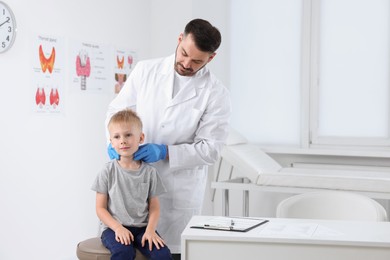 Photo of Endocrinologist examining boy's thyroid gland at hospital. Space for text