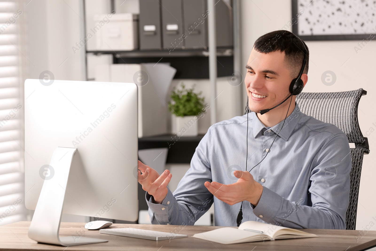 Photo of Hotline operator with headset working in office