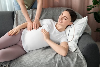 Doula taking care of pregnant woman at home. Preparation for child birth