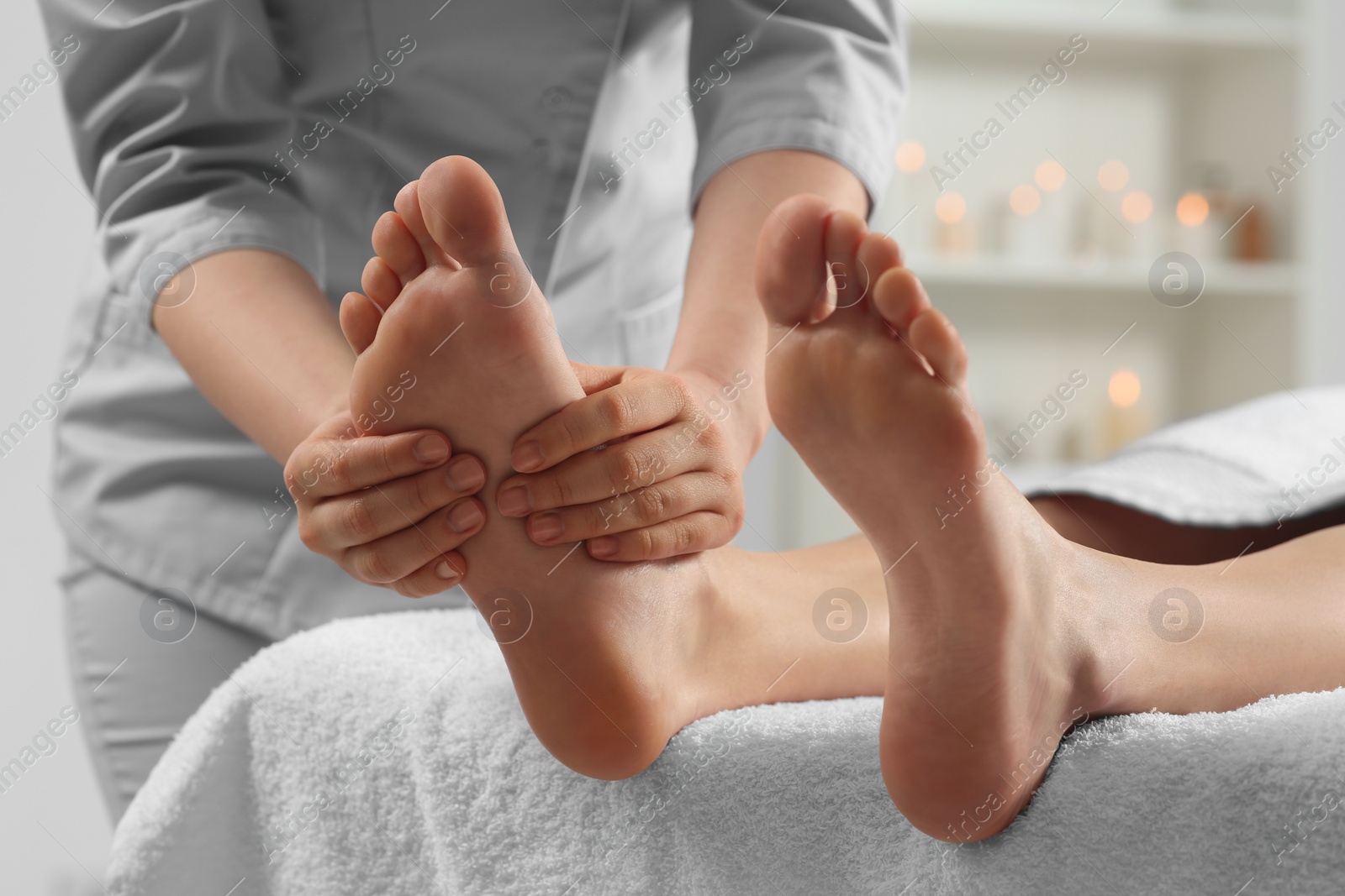 Photo of Woman receiving foot massage in spa salon, closeup