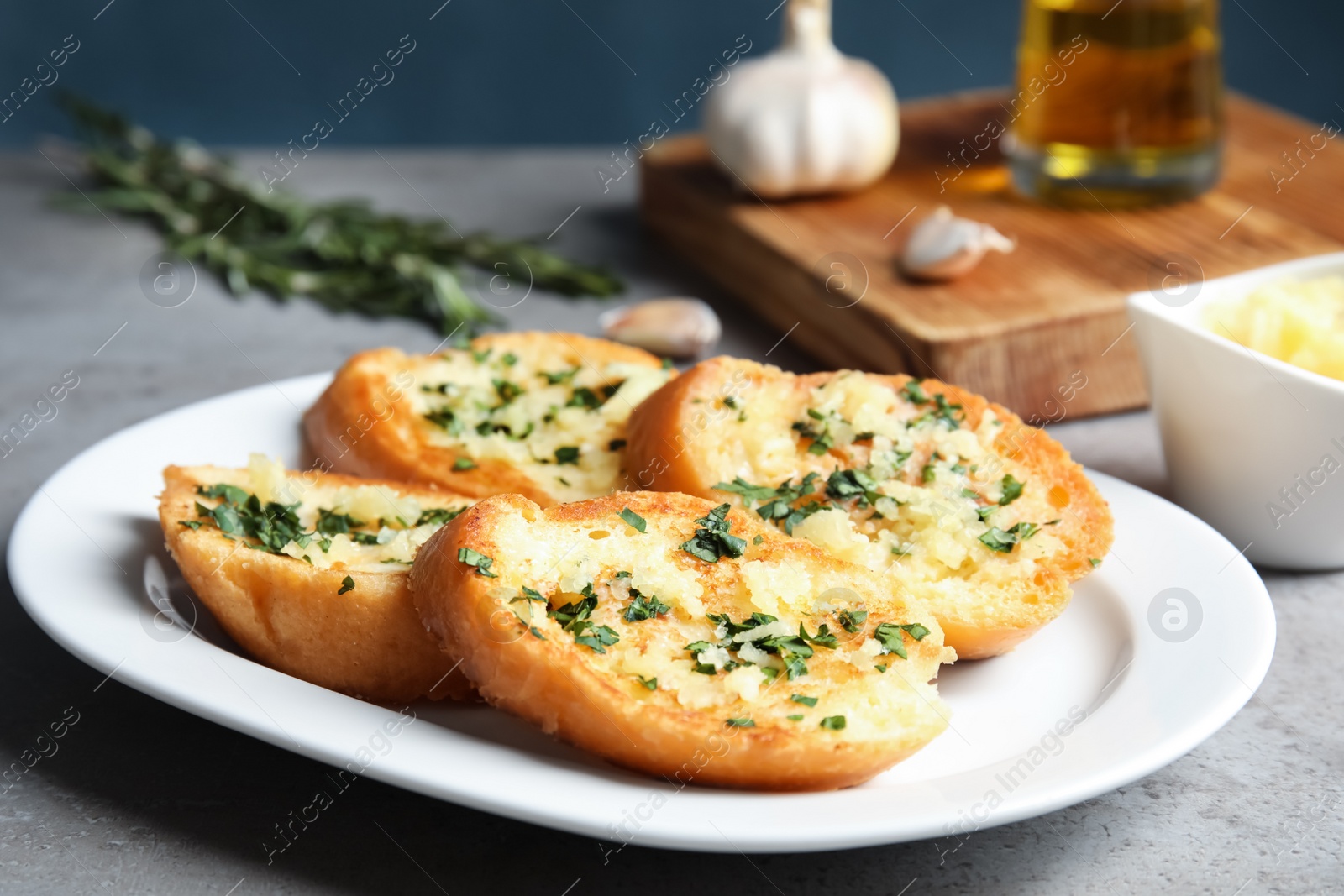 Photo of Plate with delicious homemade garlic bread on table